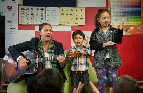 A teacher and two primary students singing together. 