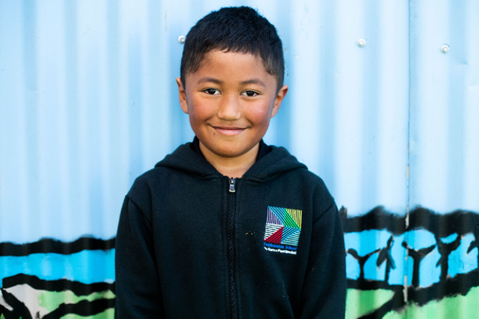 Little boy standing, facing camera and smiling