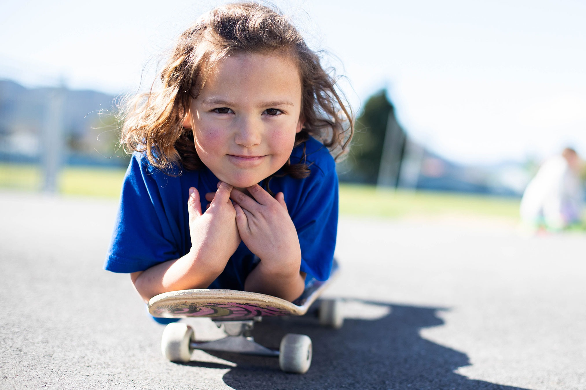 Child laying on a skateboard.