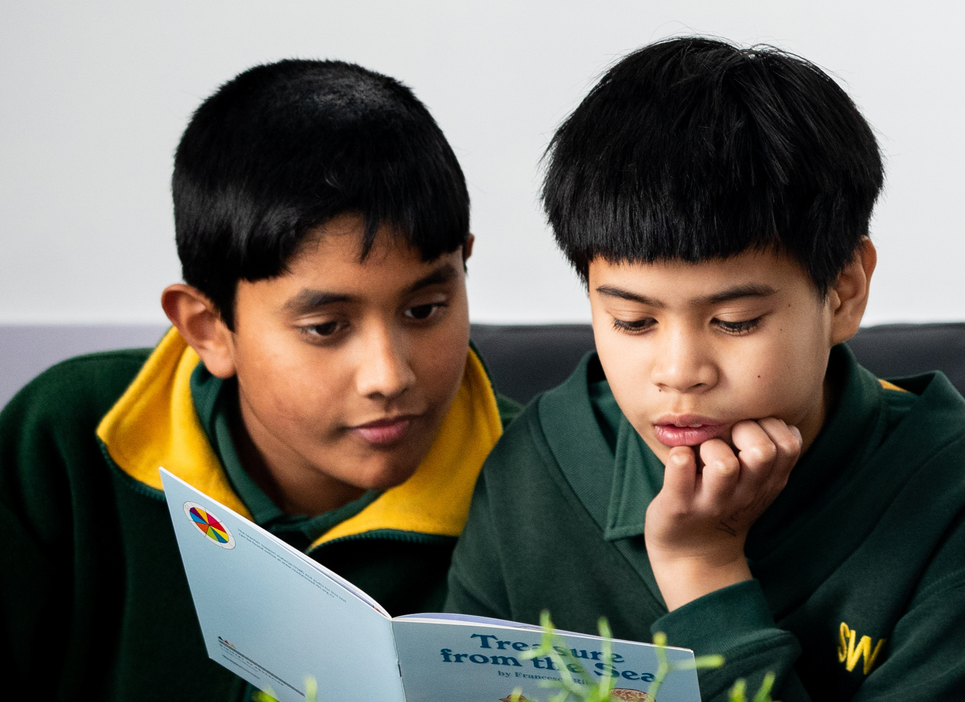 two students reading a book together