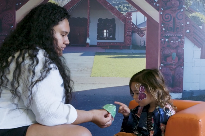 Teacher showing child a game