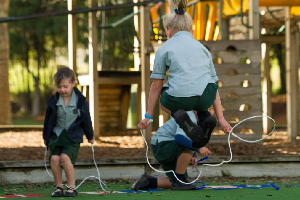 Ākonga skipping with skipping ropes in school playground