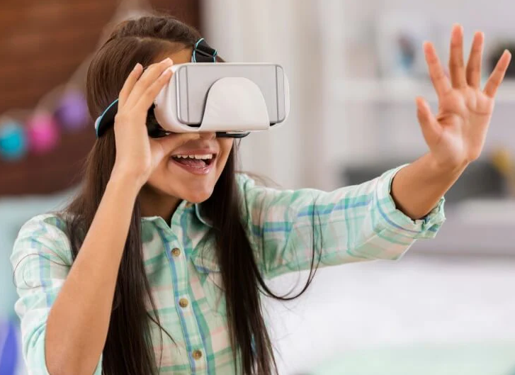 Person smiling with their hand outstretched, wearing virtual reality glasses.