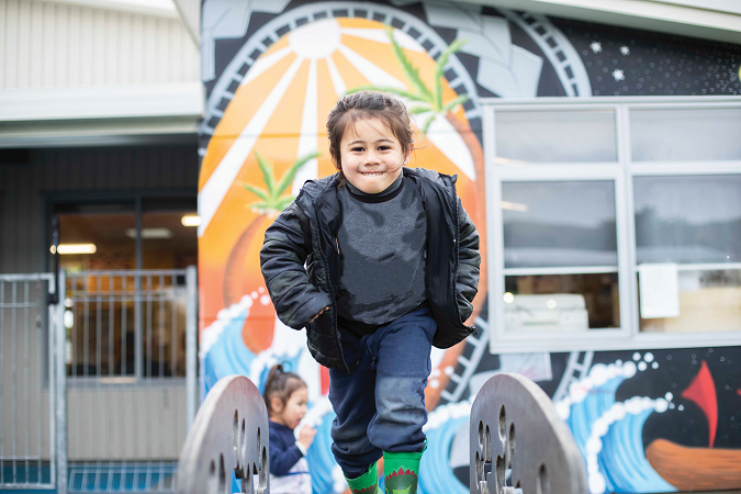 A young child running forwards towards the camera.