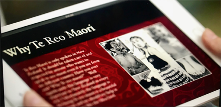 Photograph of a device open to a webpage with a heading that reads, “Why te reo Māori?”, text and photographs of tamariki in hapa haka clothes. 