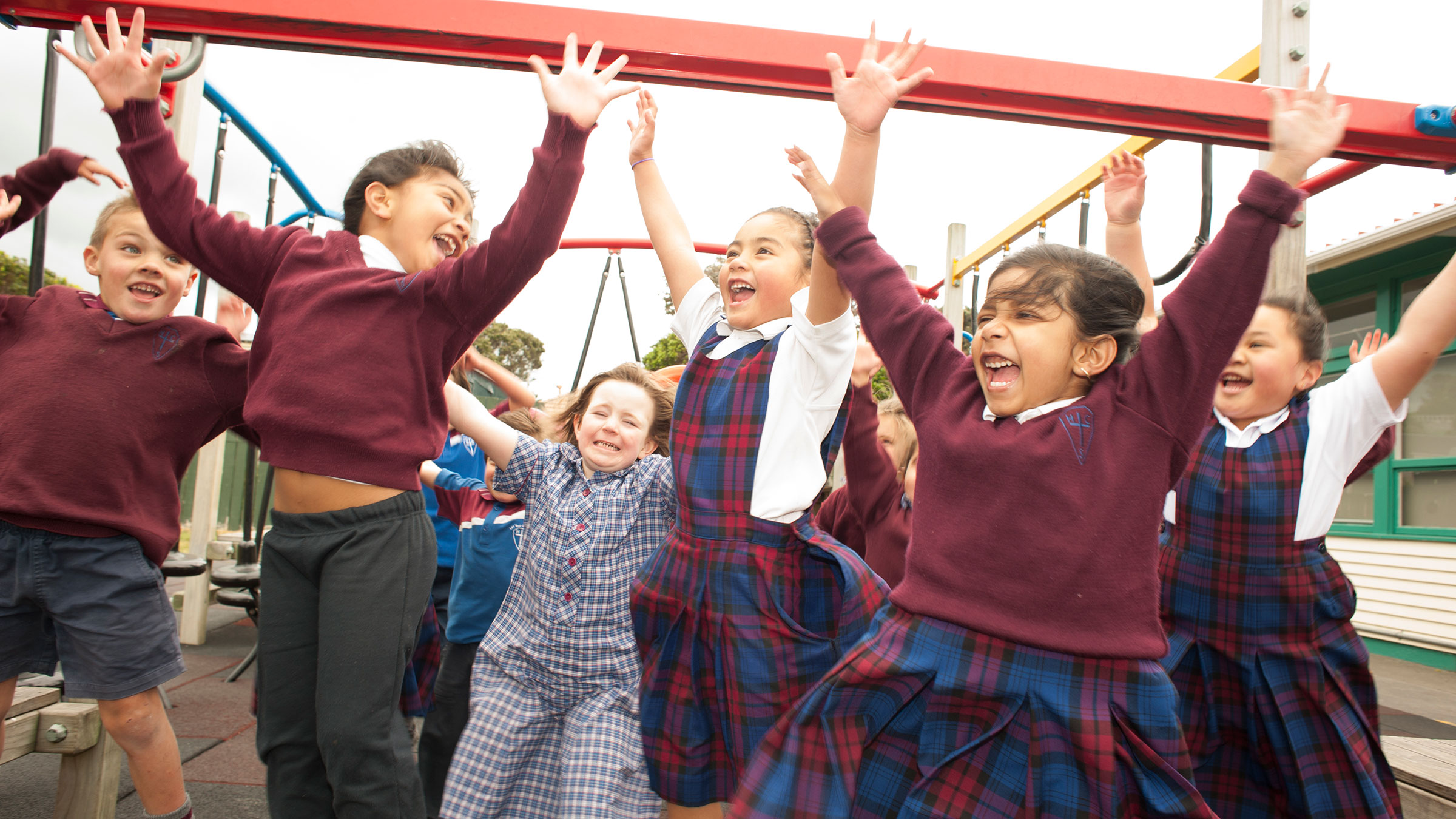 A group of students jumping, smiling and cheering. 