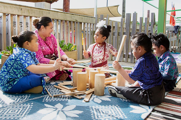 Kaiako playing drums with a group of children