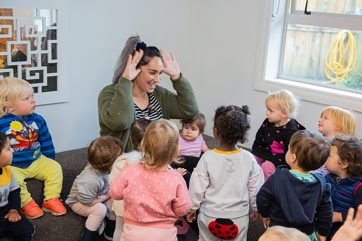 kaiako with a group of children learning a song together