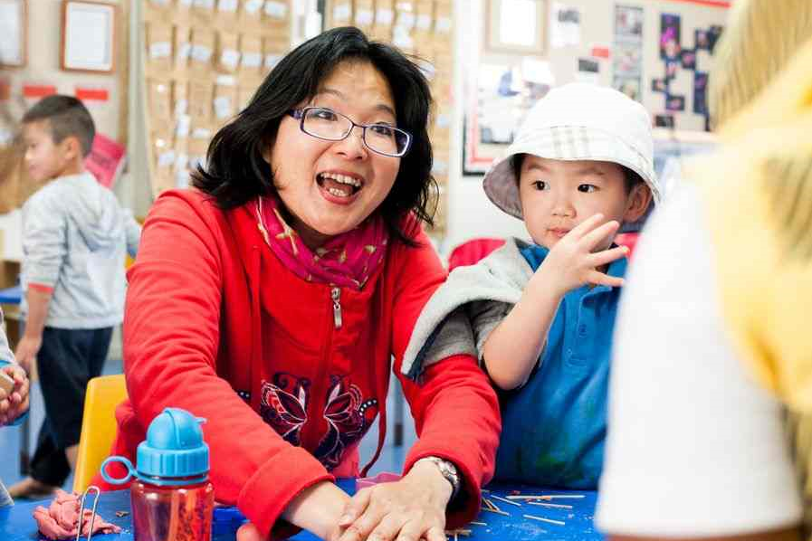  A kaiako and two children playing together at a table