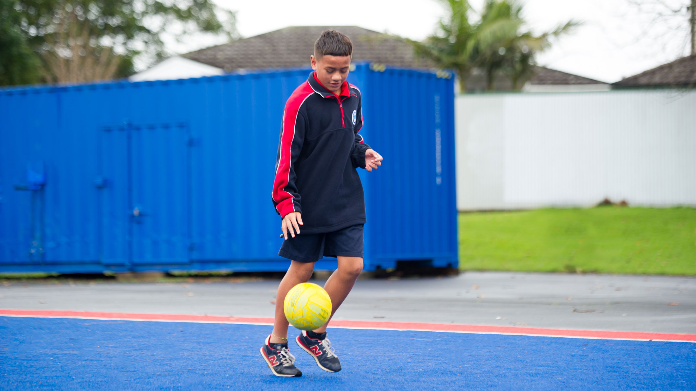 A student playing with a football outdoors. 