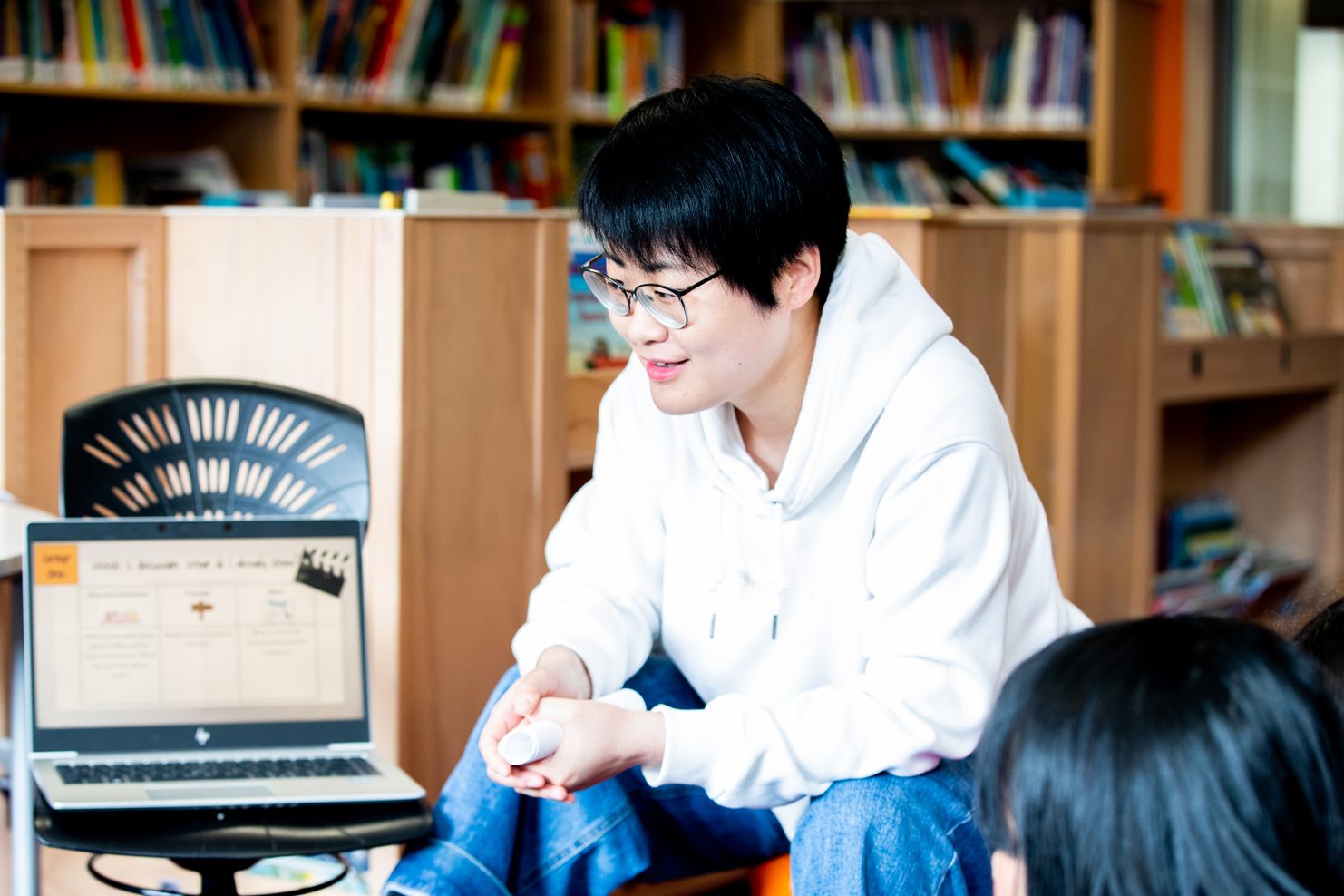 Kaiako using a laptop to show students a presentation.