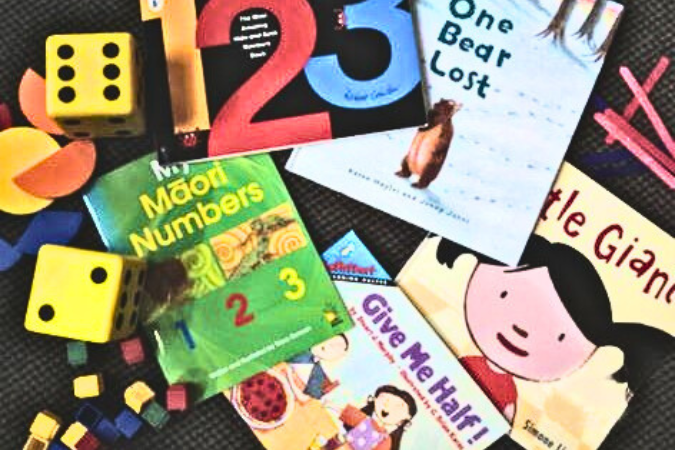 A collection of picture books and playing pieces scattered across the floor.