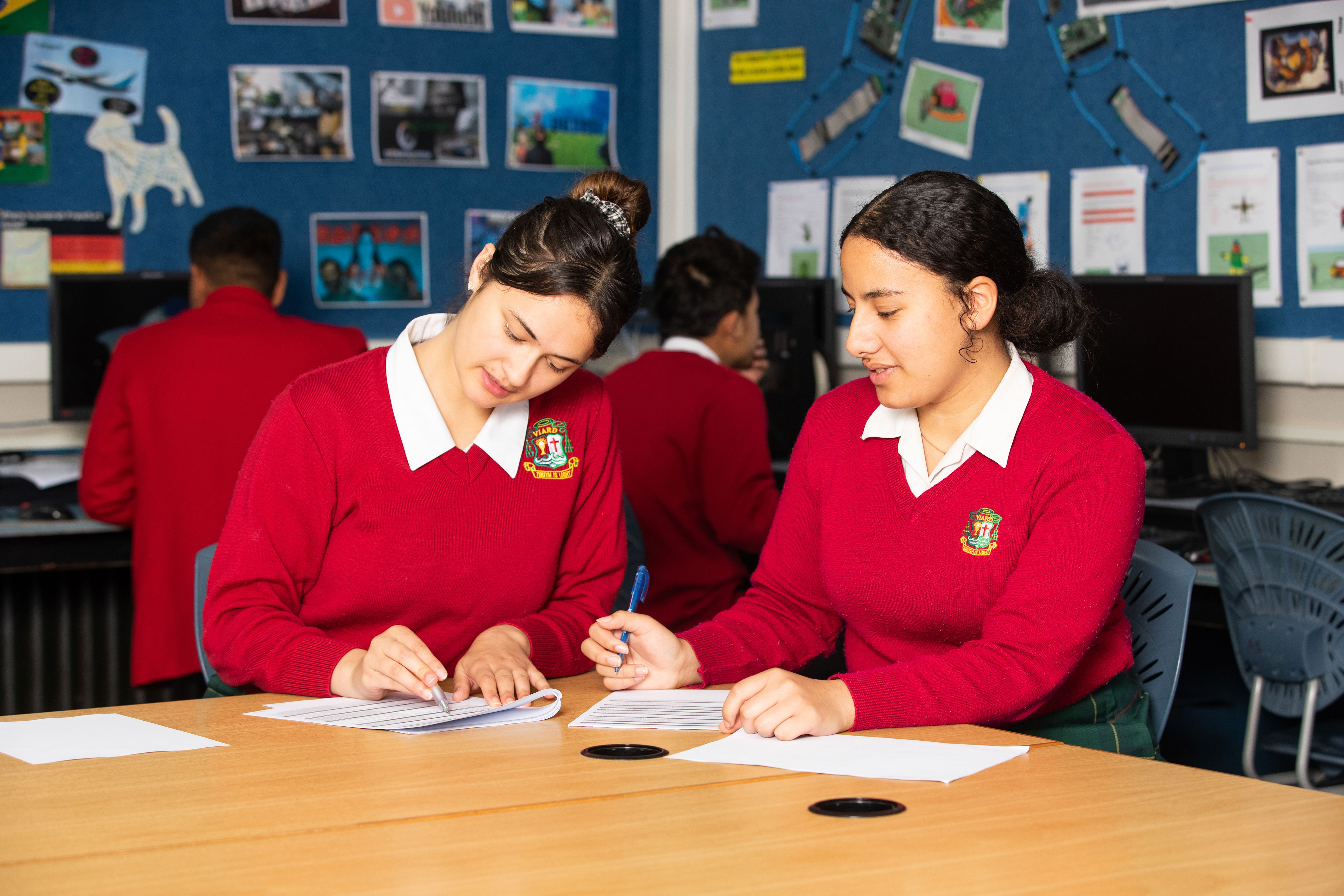 Two ākonga seated and working together in a classroom. 