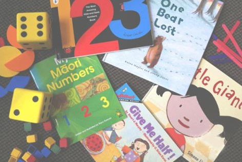 A collection of picture books and playing pieces scattered across the floor.