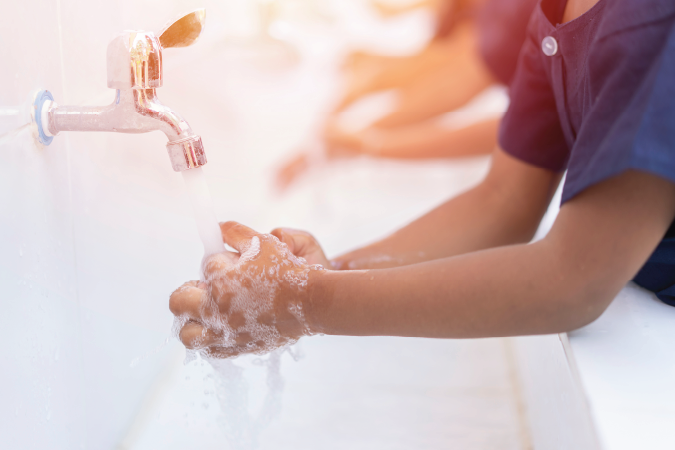 Child washing their hands with soap.