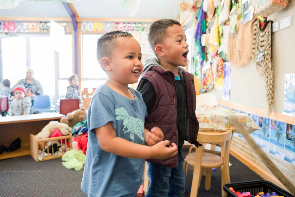 Two tamariki singing together.