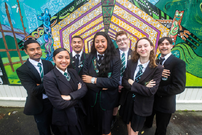 Ākonga stand in front of a mural at school.