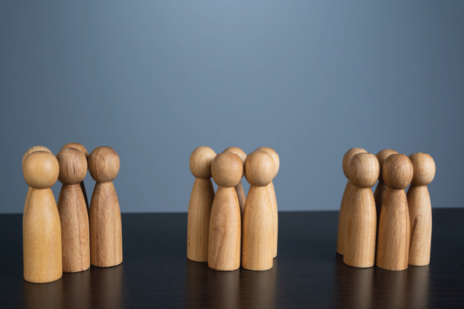 A row of wooden figures standing together in groups.