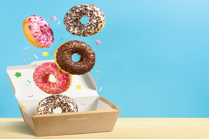 5 doughnuts emerging from a box. 