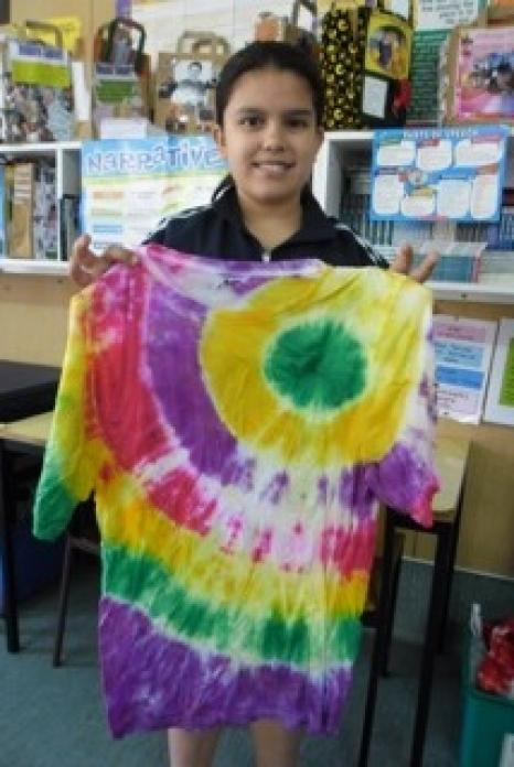 A student holding their finished tie dye t-shirt.