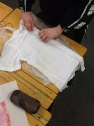 A white T-shirt being pleated being dyeing.