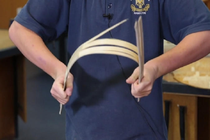 Student splitting a piece of bamboo.