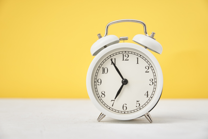 An alarm clock on a yellow background.