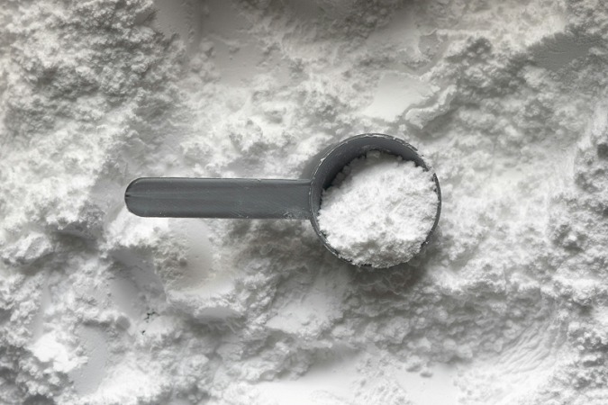 A measuring cup full of a white powder.