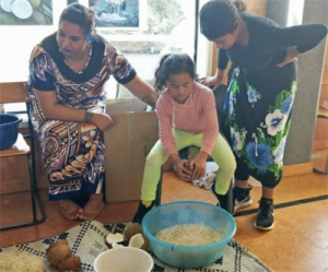 Student learning how to valuga popo (scrape the coconut).