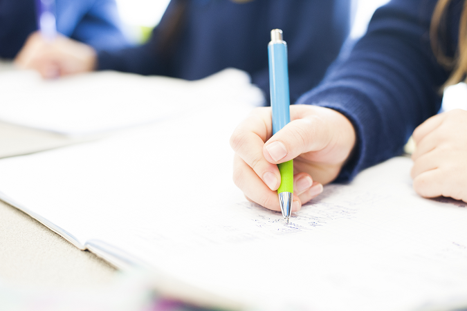 Person writing on a piece of paper.