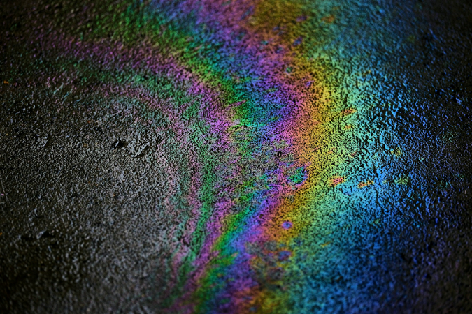Rainbow oil patch on a tarmac surface.