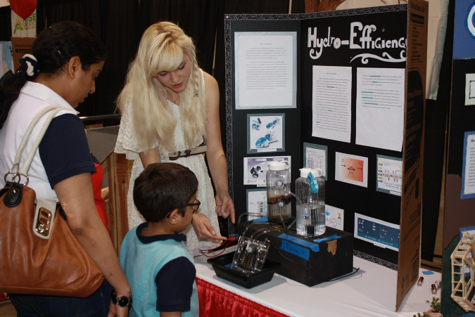 A student explaining her science fair project.