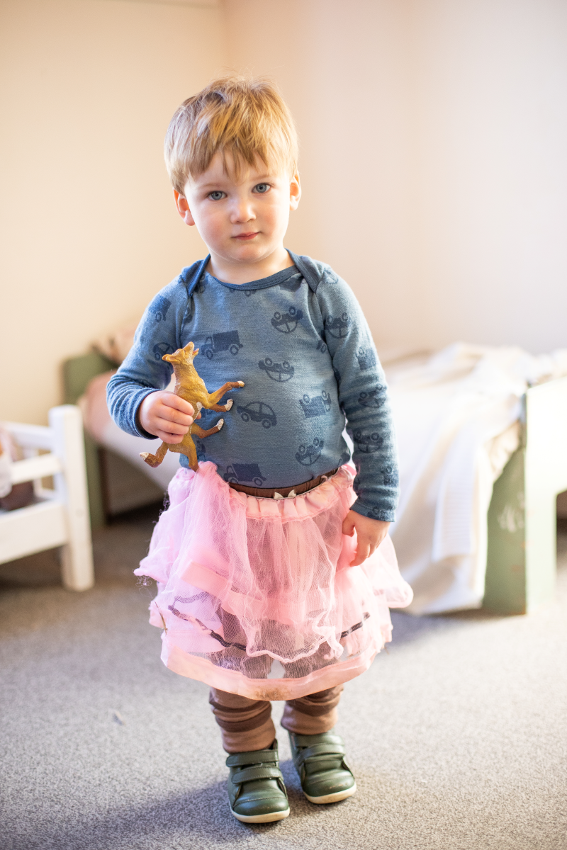 A child with a tutu and toy animal.