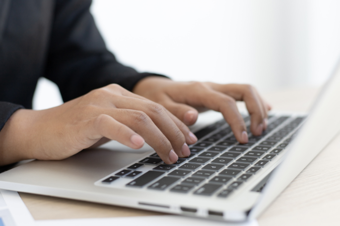 Hands typing on a keyboard.