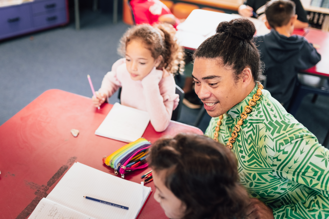 Adult working with two students at a table