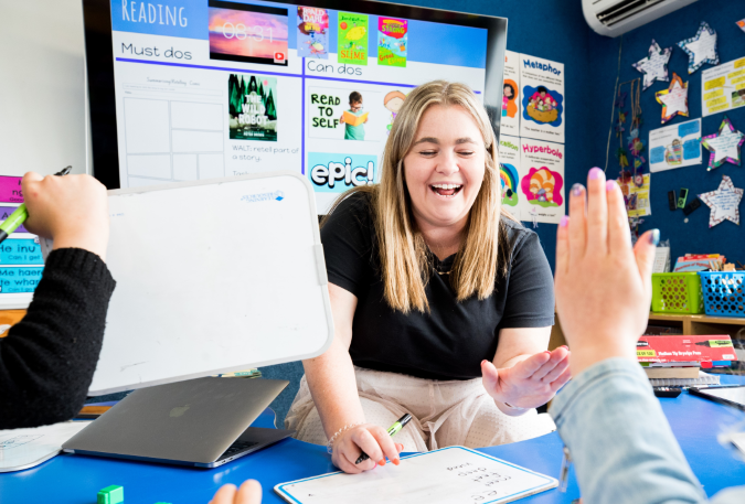 Teacher with a small group of students using portable whiteboards.