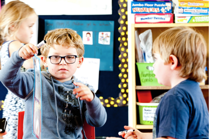 Two students working with paper crafts.
