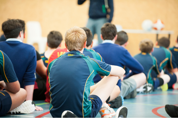 students in PE uniform facing a teacher